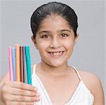 Portrait eines Mädchens hält Stifte und Lächeln