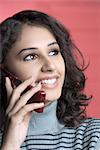 Close-up of a young woman talking on a mobile phone and smiling