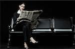 Femme d'affaires assis sur un banc et lire un journal