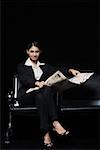 Portrait d'une femme d'affaires assis sur un banc et tenir un journal