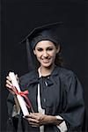 Portrait of a young female graduate holding a diploma