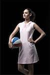 Jeune femme debout et tenant un volley-ball