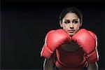 Close-up of a young woman wearing boxing glove and thinking