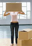 Young woman holding a cardboard box in front of her face