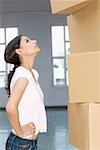 Side profile of a young woman looking at a stack of boxes