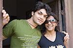 Portrait of a young couple smiling at a doorway, Goa, India