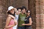 Portrait of two young couples standing together and smiling, Goa, India