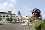 Young man taking a picture of a cathedral with a mobile phone, Se Cathedral, Goa, India