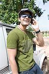 Junger Mann von einem Jeep stehen und reden auf einem Mobiltelefon, Goa, Indien