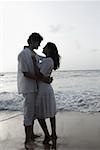 Side profile of a young couple embracing each other on the beach