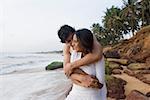 Jeune homme embrassant une jeune femme sur la plage