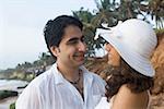 Gros plan d'un jeune couple regardant les uns les autres et souriant sur la plage, Goa, Inde