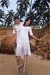 Young couple walking on a tree trunk