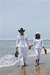 Young couple walking with holding hands on the beach
