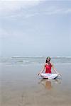 Junge Frau meditieren am Strand