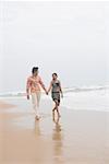 Jeune couple marchant avec main dans la main sur la plage