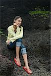 Young woman sitting on a rock and thinking