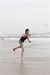 Young man playing with a plastic disc on the beach