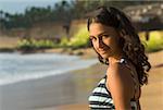 Portrait d'une jeune femme debout sur la plage et ricaner