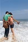 Jeune couple embrassant l'autre sur la plage