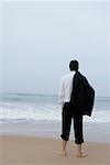 Rear view of a businessman standing on the beach