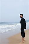 Side profile of a businessman standing on the beach