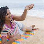 Young woman playing with sand on the beach