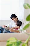 Mid adult man reading a book with his daughter