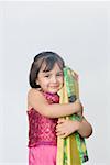 Portrait of a girl hugging packets of firecracker and smiling