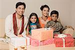 Close-up of gifts on a table in front of two generation family