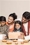 Jeune couple avec leur fils et fille holding diwali cadeaux