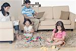 Mid adult couple with their two daughters in a living room