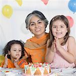 Portrait of a mature woman celebrating her birthday with her two granddaughters