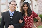 Portrait of a mature man and his daughter smiling with their arm in arm