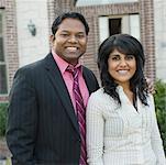 Portrait of a mid adult man standing with his arm around a young woman and smiling