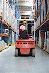 Young man sitting on a fork lift