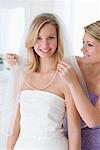 Woman Helping Bride Get Dressed