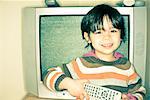 Boy Standing in Front of Television, Holding Remote