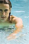 Man in swimming pool, looking at camera, cropped