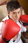 one man with boxing gloves sitting on the sofa