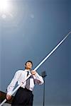 a man in business suit with a pole in his hand