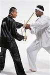 two men practicing nunchakus