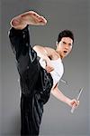 a man practicing nunchakus