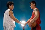 zwei männliche Basketballspieler ihre Hände schütteln