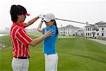 a male golfer teaching a female