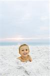 Little boy at the beach, smiling at camera, portrait