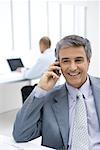 Businessman using cell phone in office