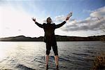 Homme d'affaires avec ordinateur portable debout dans le lac Windermere, Cumbria, Angleterre