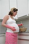 Femme enceinte de cuisson dans la cuisine