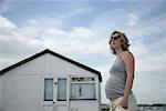 Femme enceinte debout près de la cabane de plage